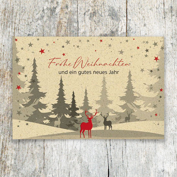 Karte aus beigegrauem Karton mit stilisiertem Waldmotiv und rot geprägtem Hirsch.