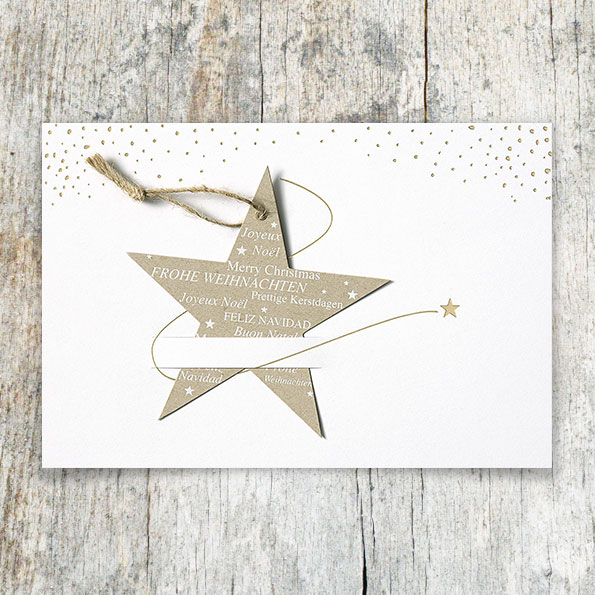 Cremefarbene Weihnachtskarte mit eingestecktem Stern aus braunem Kraftpapier.